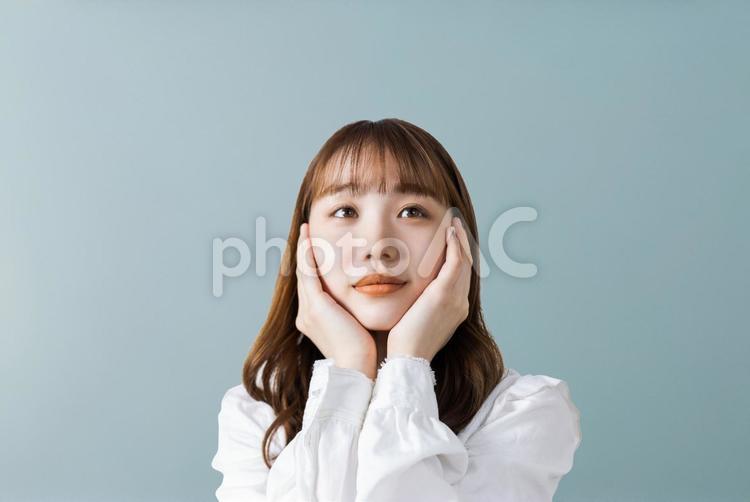 両手で頬を押さえて考えるビジネスウーマン 女性,ビジネス,ビジネスウーマンの写真素材