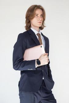 ノートパソコンを抱えているスーツの男性 男性,外国人,欧米人の写真素材