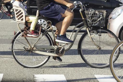 過十字路口的自行車的父母和孩子 過十字路口的自行車的父母和孩子