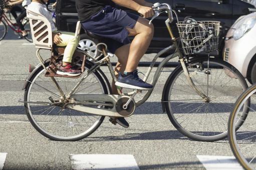 Parent and child of a bicycle crossing an intersection, JPG