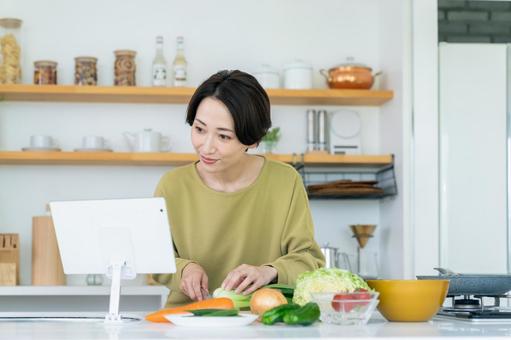 キッチンで調理するミドルの女性 キッチンで調理するミドルの女性 調理,料理,キッチンの写真素材