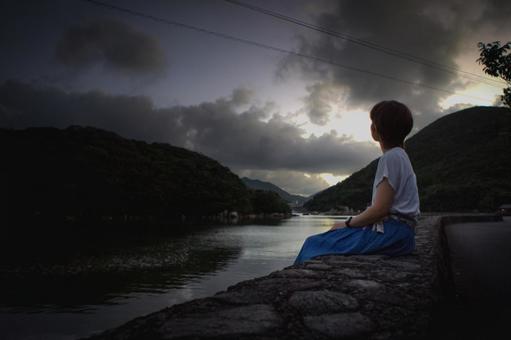 <素材>暗い夕暮れの海を一人散策する女性 <素材>暗い夕暮れの海を一人散策する女性の写真