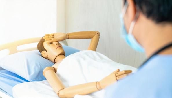 病院のベッドに横たわるリアルな木製人形 病院のベッドに横たわるリアルな木製人形の写真