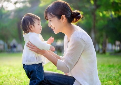 緑の中で遊ぶ、子と母親 緑の中で遊ぶ、子と母親の写真