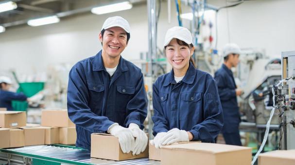 ライン作業中の笑顔の作業員 ライン作業中の笑顔の作業員の写真