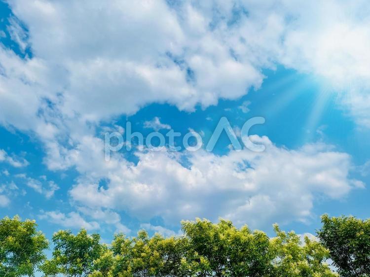 美しい青空と、白い雲と太陽の光の背景 空,太陽,光の写真素材