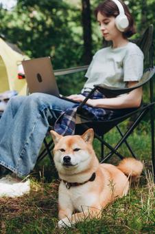 犬と寄り添って座る女性の写真
