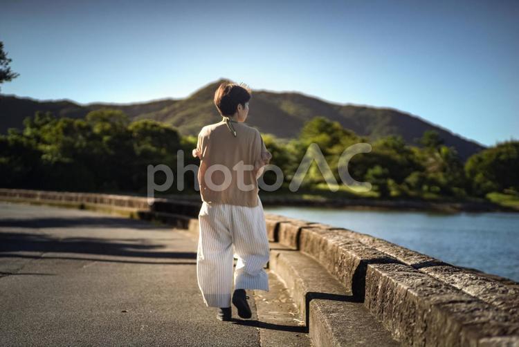 ＜素材＞旅行で夜明けの海を散策する女性 女性,人物,風景の写真素材