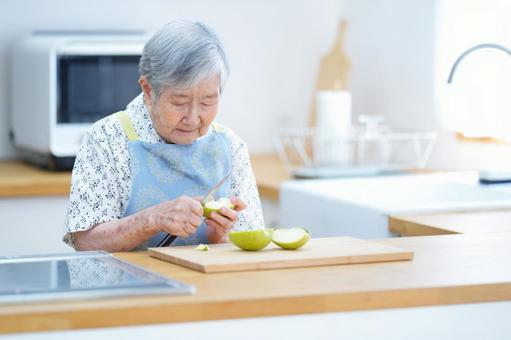 リンゴを切っているおばあちゃん 女性,リンゴ,皮むきの写真素材