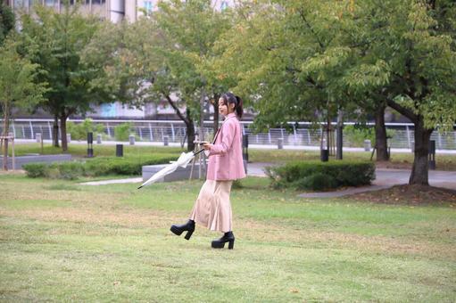 公園の芝生広場で楽しそうに歩く女性 女性,20代,公園の写真素材
