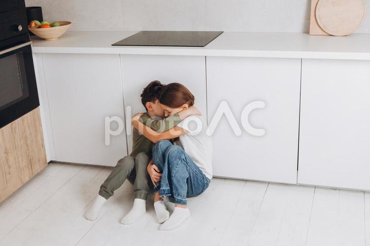 抱き合って座っている姉弟 姉弟,女の子,男の子の写真素材