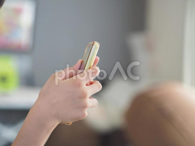 スマホの画面を見る子供の手元 スマホ,子供,小学生の写真素材
