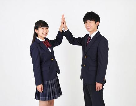 ハイタッチする高校生の男女生徒の写真