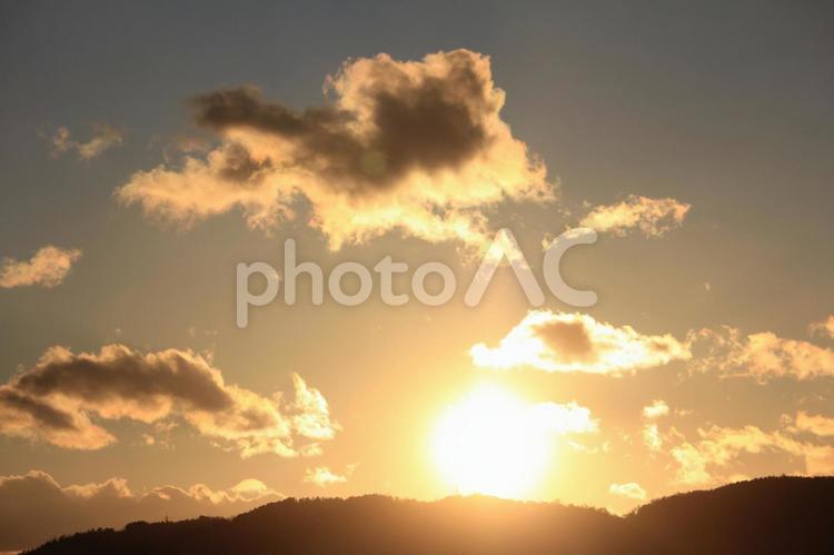 夕焼けと夕日に照らされる雲 オレンジ,山,夕日の写真素材