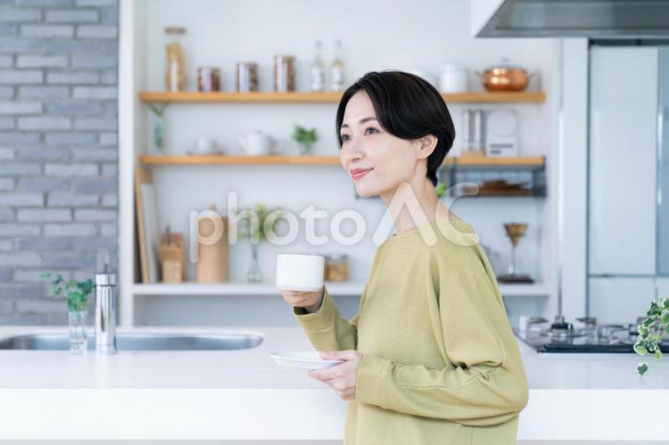 キッチンでコーヒーを飲むミドルの女性 キッチン,台所,コーヒーの写真素材