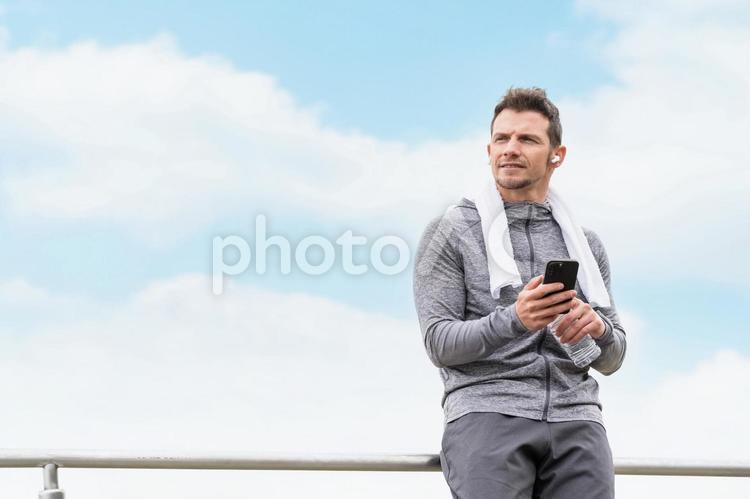 運動中にスマホで音楽を聞く白人男性 音楽,音楽配信,サブスクの写真素材