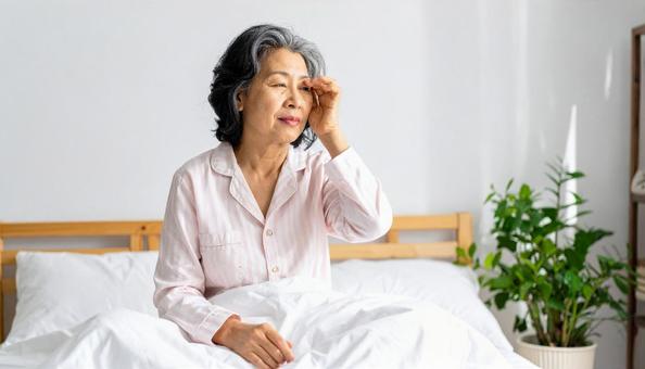 寝不足のパジャマを着た中年の日本人女性 寝不足のパジャマを着た中年の日本人女性の写真