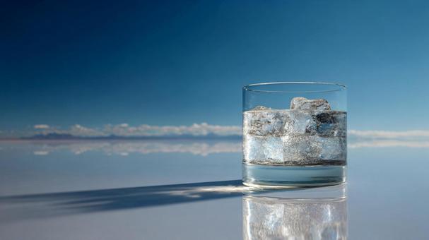 澄み切った空と水面を背景に、喉を潤す一杯 澄み切った空と水面を背景に、喉を潤す一杯の写真