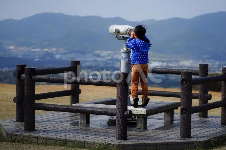 ＜人物＞山の上で双眼鏡を覗く男の子 子供,男性,小学生の写真素材