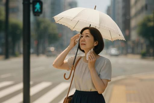日傘を差して信号待ちする女性 日傘を差して信号待ちする女性の写真