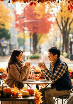 紅葉シーズンにテラスでお茶を飲むカップルの写真