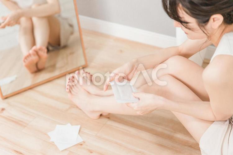 むくみケアで足裏にシートを貼る女性 足裏,シート,むくみの写真素材