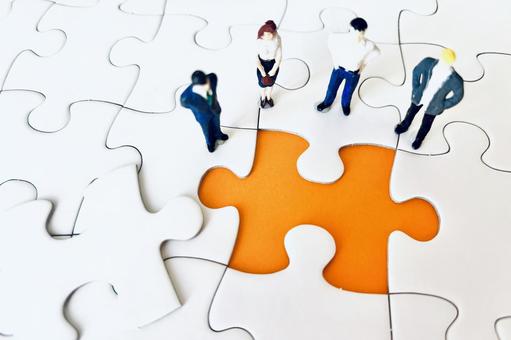 ジグソーパズルと会議するビジネスマン ジグソーパズル,パズル,打ち合わせの写真素材
