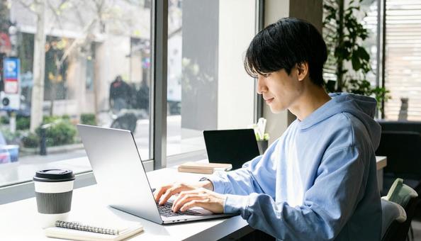 カフェで仕事をするフリーランス男性 カフェで仕事をするフリーランス男性の写真