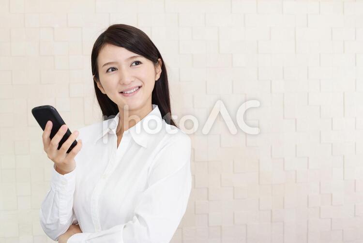 スマートフォンを持ち微笑む女性 女性,スマートフォン,女の写真素材