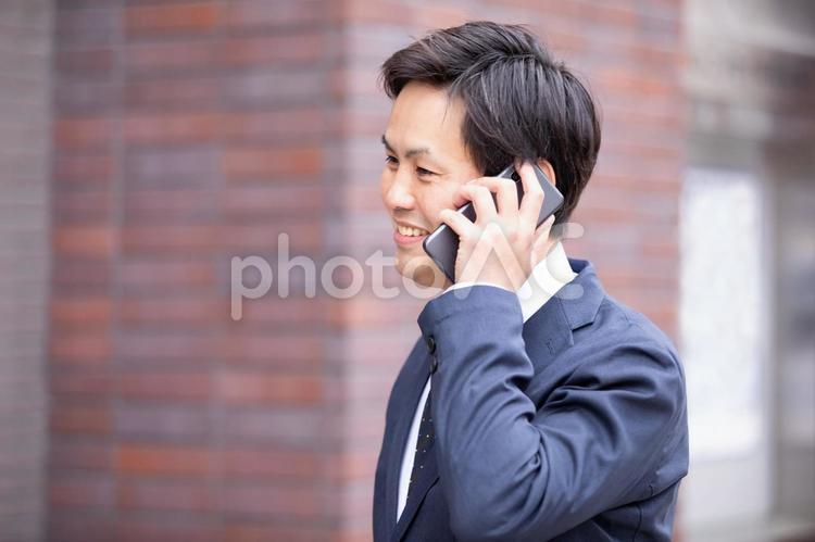 カジュアルビジネスの会社員 電話,営業マン,スマホの写真素材
