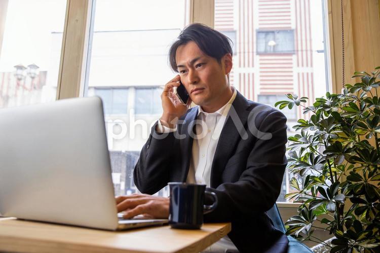 仕事するビジネスマン（真剣） ビジネスマン,ビジネス,スマホの写真素材