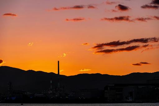 夕焼けに染まる工場地帯のシルエット 夕焼けに染まる工場地帯のシルエットの写真