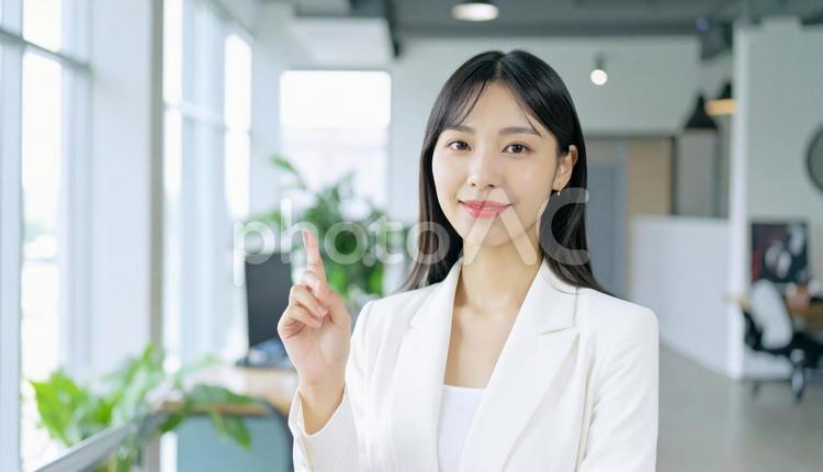 自信のある表情で指さすビジネス女性 指さす,指差し,ビジネスの写真素材