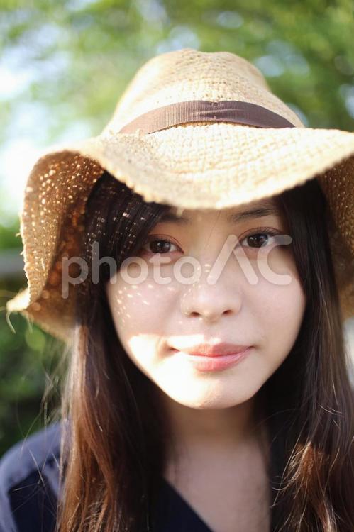 麦わら帽子の女性の顔のアップ 女性,日差し,夏の写真素材