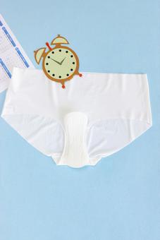 ショーツと生理用ナプキンと紙でできた時計とカレンダー 生理,月経,生理用品の写真素材