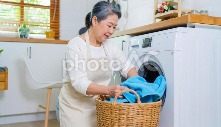 洗濯機を使う日本人の高齢者女性 ランドリー,洗濯機,ハウスクリーニングの写真素材