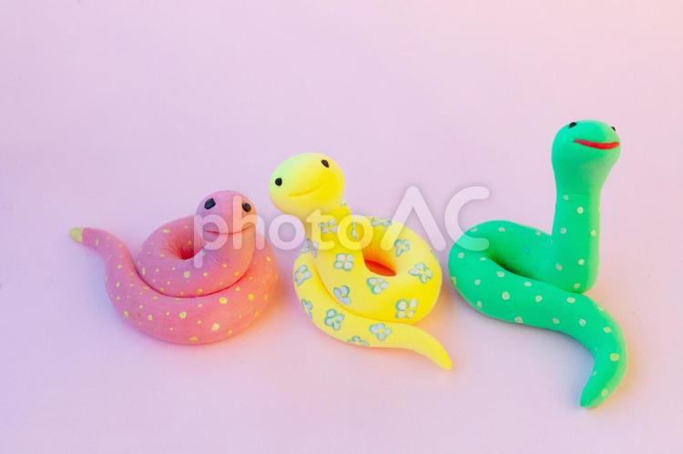 ピンクの背景に黄色赤緑の蛇たち 蛇,クレイアート,動物の写真素材