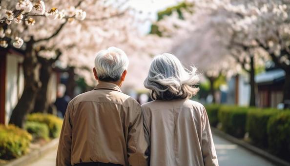 桜並木を歩く仲良しのシニア夫婦 桜並木を歩く仲良しのシニア夫婦の写真
