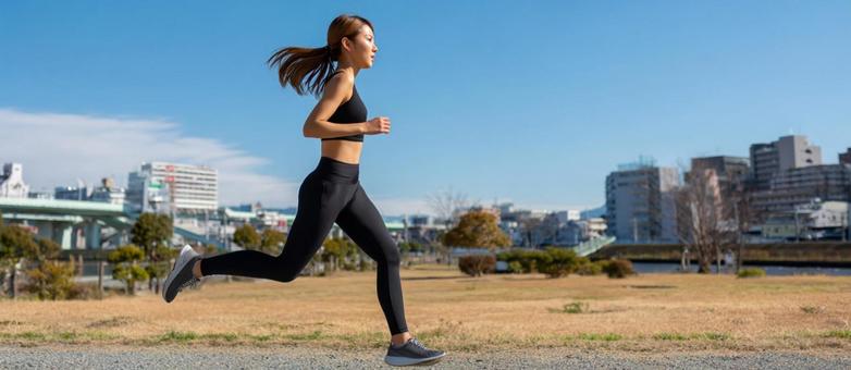 青空の下、軽やかに走る女性ランナーの写真