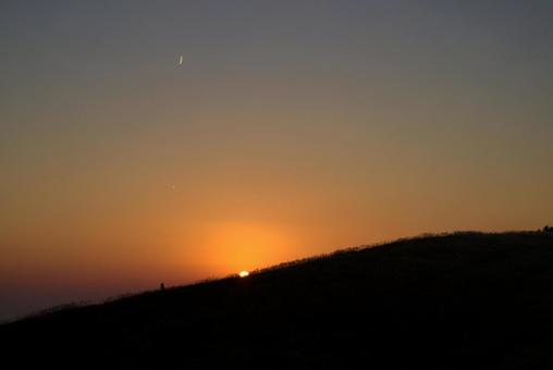 水平線に沈む夕陽と三日月とススキの丘 水平線に沈む夕陽と三日月とススキの丘 夕陽,空,三日月の写真素材