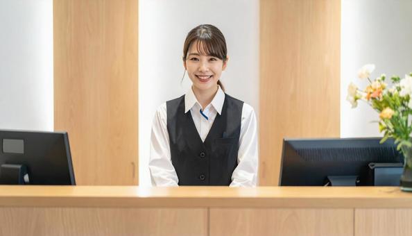 笑顔で対応する女性の受付嬢 笑顔で対応する女性の受付嬢の写真