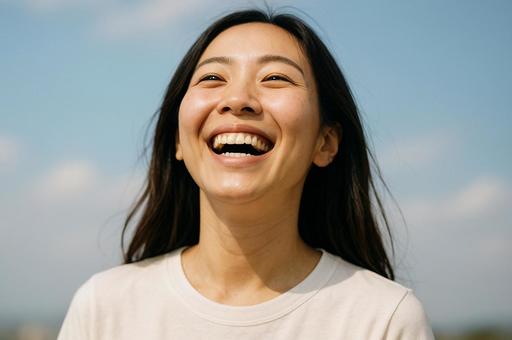 青空の下で笑う女性の写真