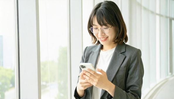 スマホを確認するビジネス女性 スマホを確認するビジネス女性の写真