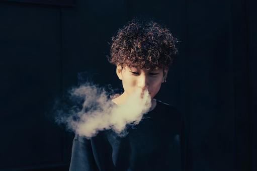 煙を吐く男性 煙を吐く男性の写真