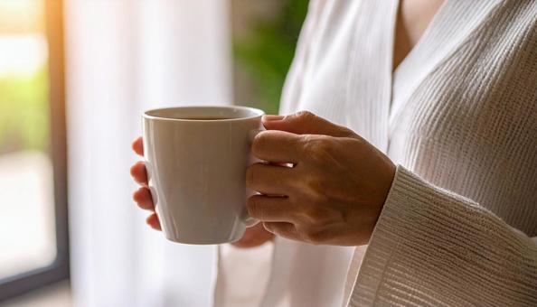 コーヒーカップを手にする女性の手 コーヒーカップを手にする女性の手の写真