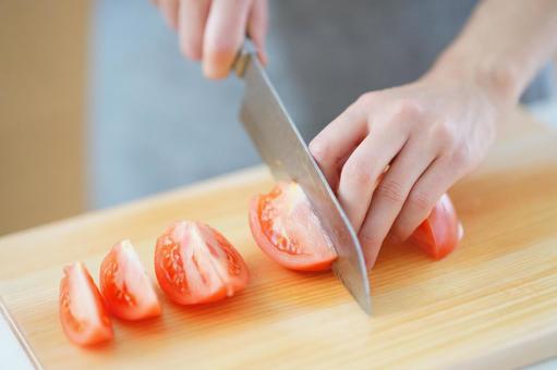 トマトをくし切りに切っている手 トマト,赤,切るの写真素材