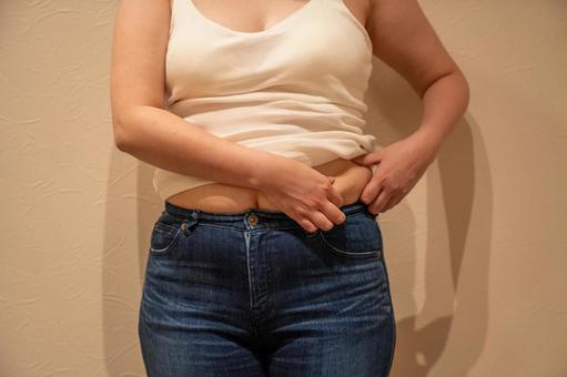  デニムパンツの上に乗るお腹のぜい肉6 ダイエット,セルライト,脂肪燃焼の写真素材