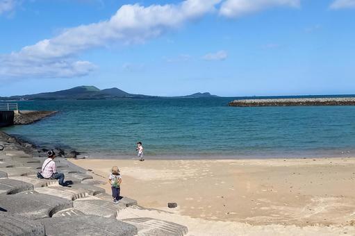 ＜素材＞夏の海で子供が遊ぶ姿を見守る母 家族,親子,女性の写真素材