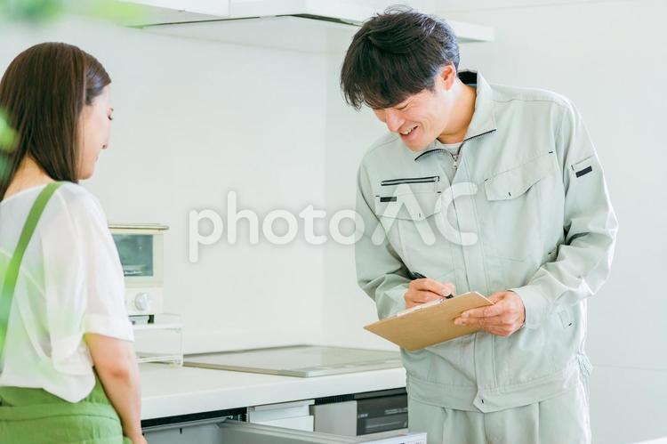 作業着姿の男性と女性（食洗機） 食洗機,食器洗い乾燥機,作業服の写真素材