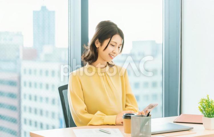 スマホを使う笑顔の女性・ビジネスウーマン 女性,スマホ,スマートフォンの写真素材